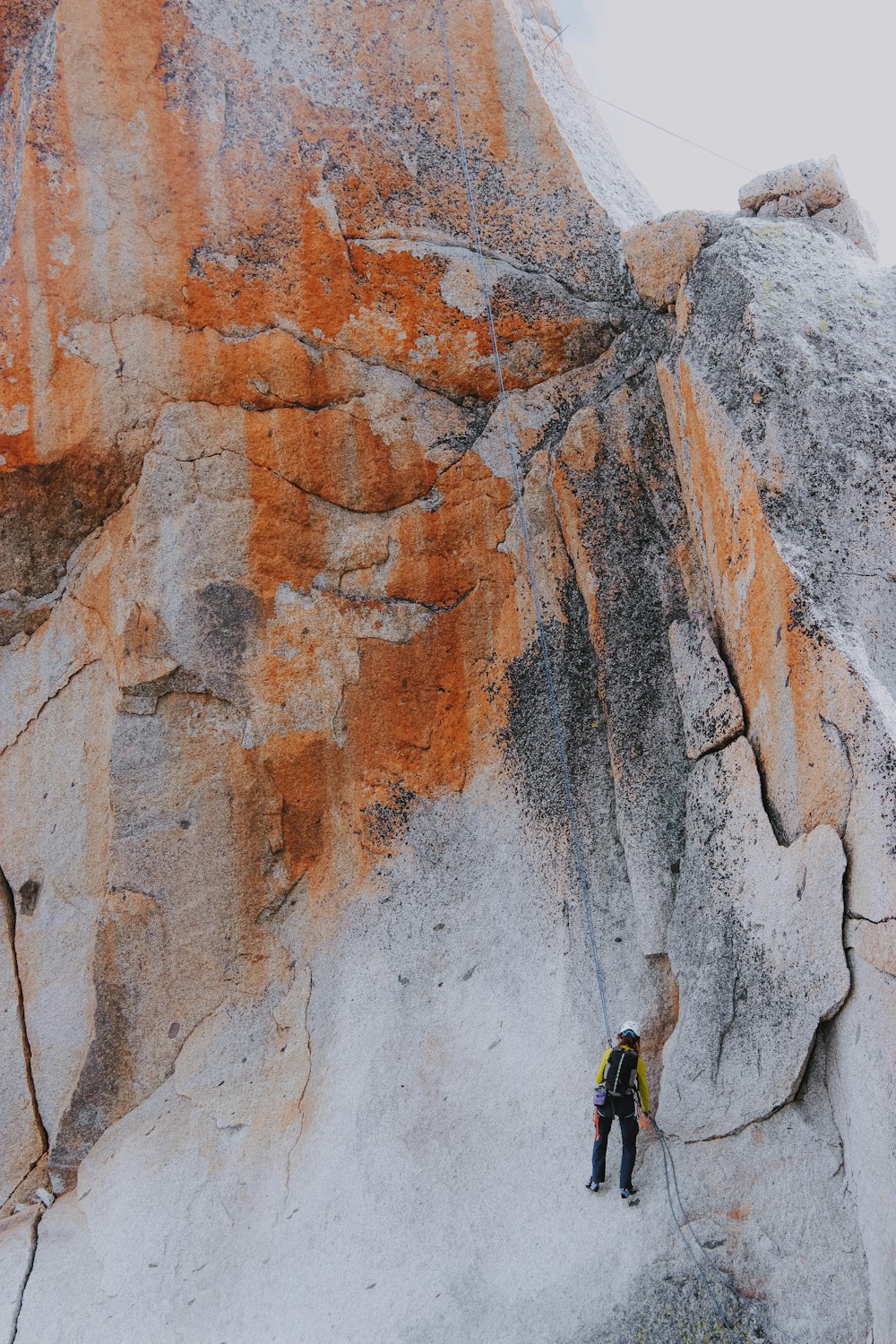 person climbing side of mountain