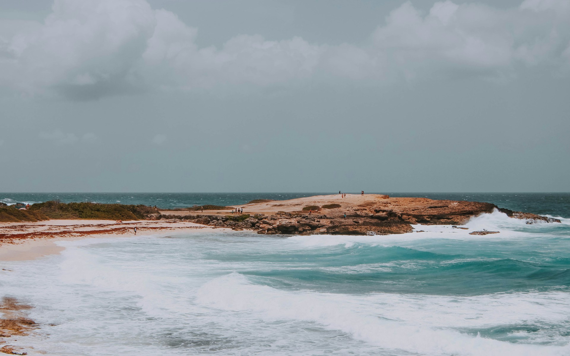 people near the shore during cloudy sky
