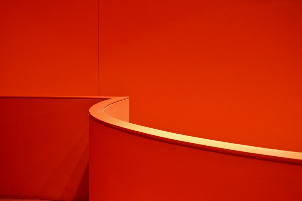 a red wall with a curved corner in the center