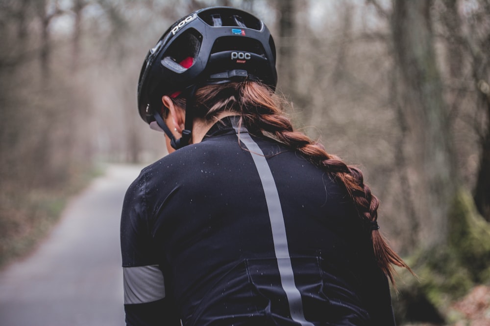 mulher no capacete de ciclismo POC preto