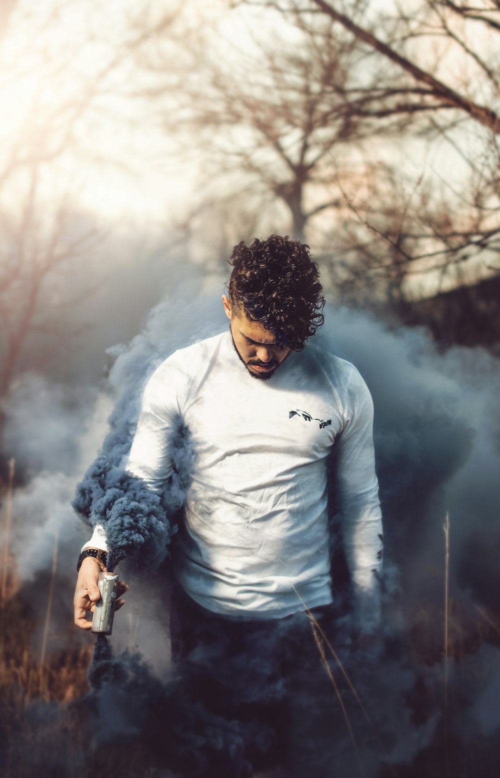 man holding gray smoke bomb\