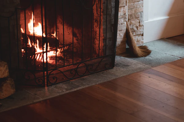 Warm fireplace with wood floors and hearth broom