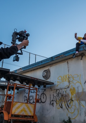 man taking a video of a person on roof