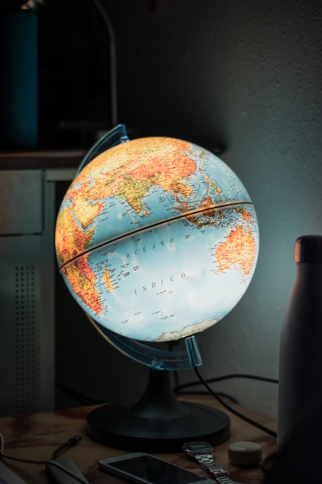 A compact smart gadget for travelers, glowing softly on a wooden table with travel maps around.