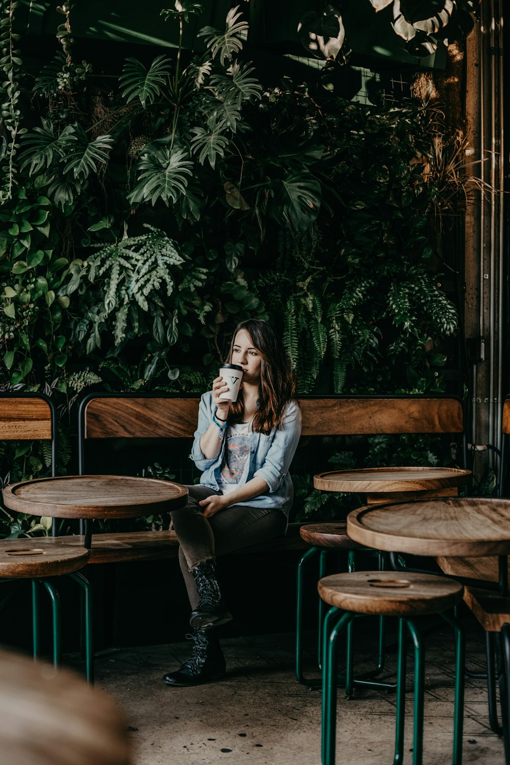 woman sitting at the end of the room drinking from cup