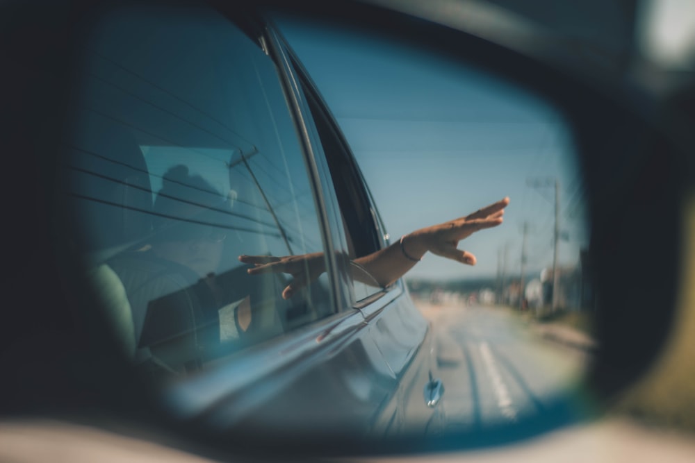 person putting hand outside of window