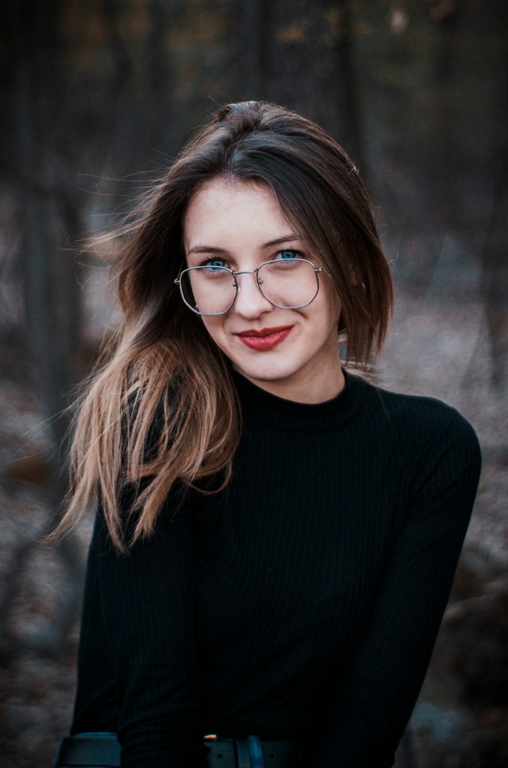 woman wearing eyeglasses and black long-sleeved shirt outdoor