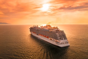 white ship on sea during sunset