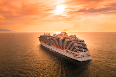 white ship on sea during sunset