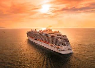 white ship on sea during sunset