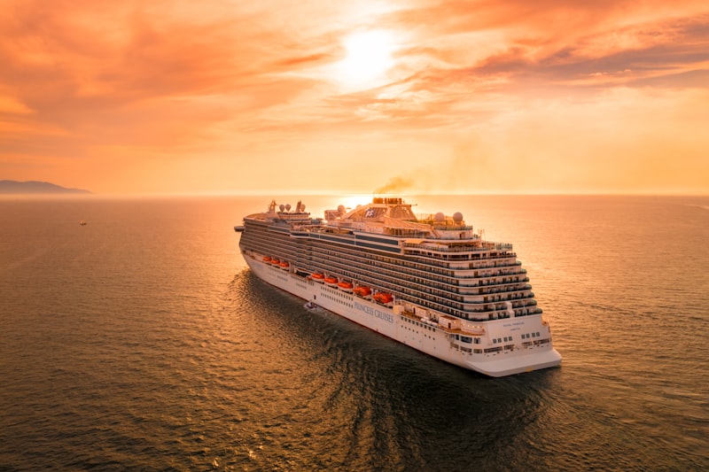 Luxury cruise ship sailing at golden hour on calm ocean waters