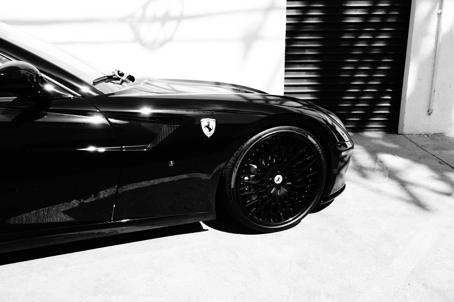 Ferrari noire en showroom, reflets sur la carrosserie