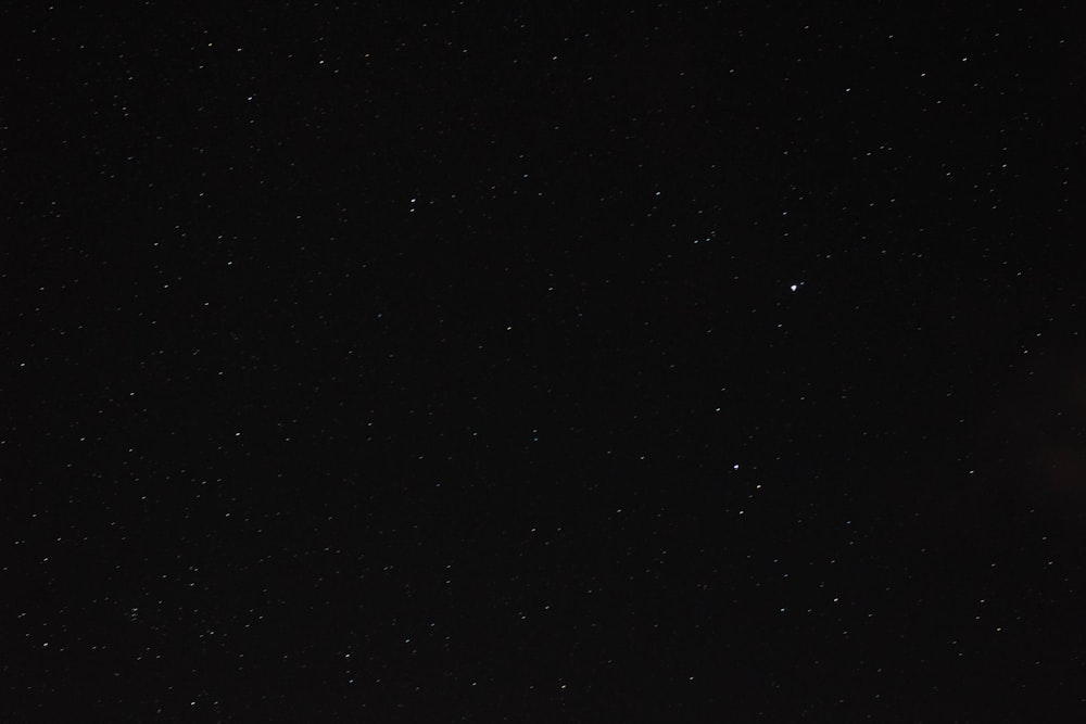 a night sky with stars and a street light