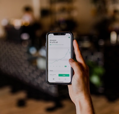 person holding black iPhone displaying stock exchange