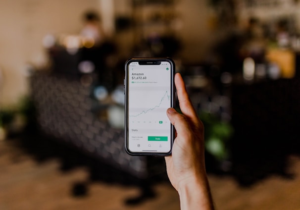 person holding black iPhone displaying stock exchange