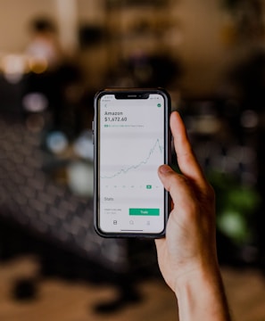 person holding black iPhone displaying stock exchange