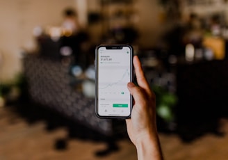 person holding black iPhone displaying stock exchange