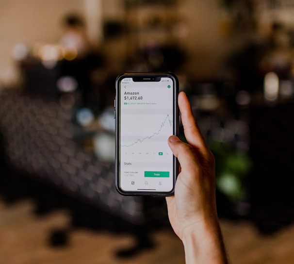 person holding black iPhone displaying stock exchange