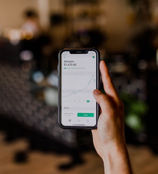 person holding black iPhone displaying stock exchange