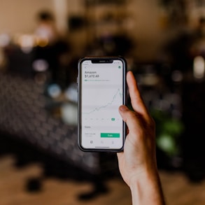 person holding black iPhone displaying stock exchange