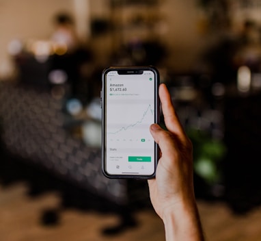 person holding black iPhone displaying stock exchange