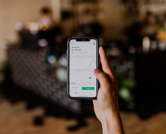 person holding black iPhone displaying stock exchange