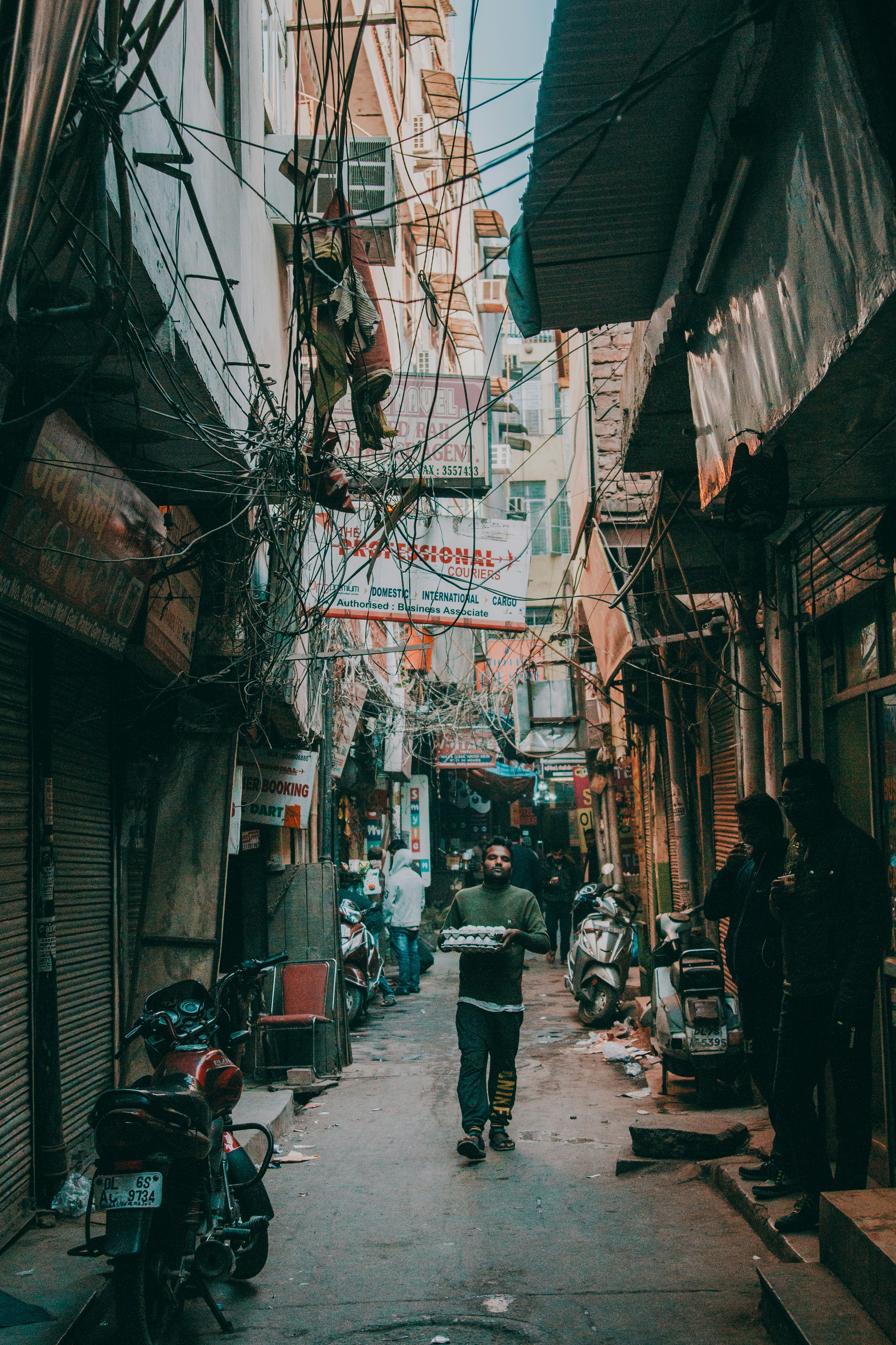 man carrying tray with eggs walking on pathway near buildings