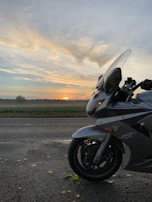 Motorbikes lined up against a mountain backdrop at sunrise, ready for the day.