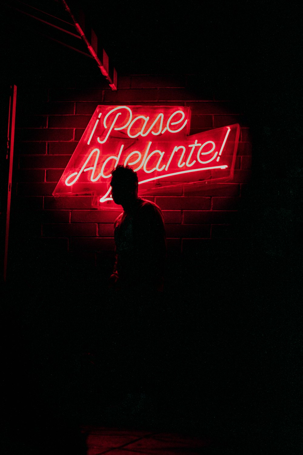 silhouette of person by neon signage