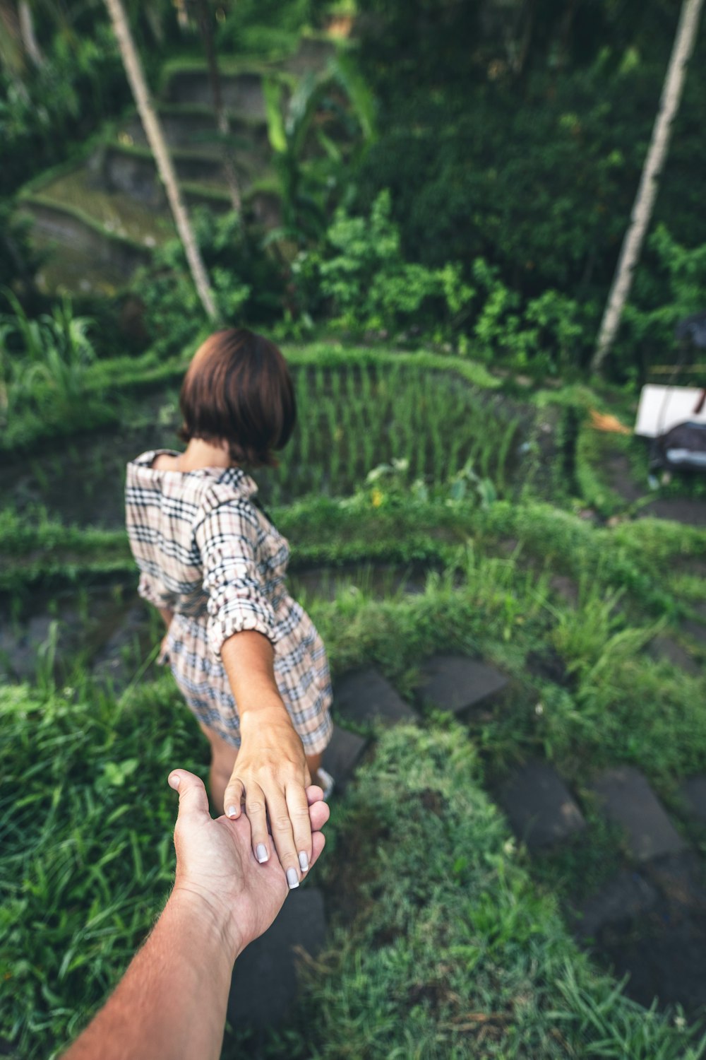 woman reaching over her back to hold a person hand