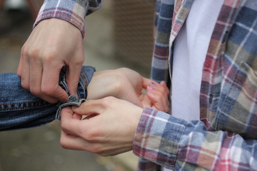 person fixing man's jacket