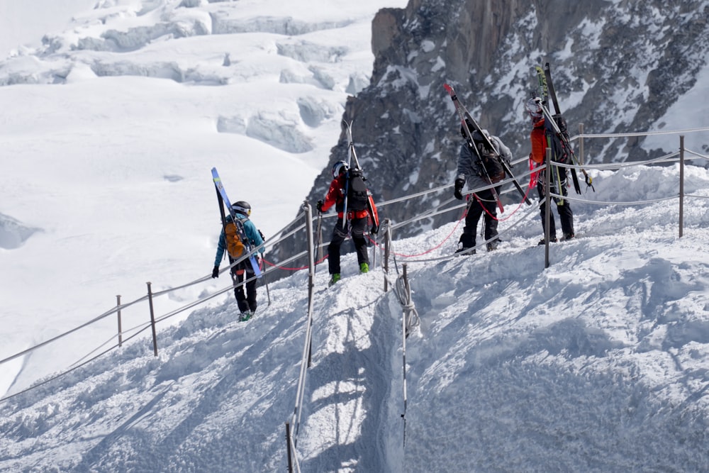 four people on mountain covered by snow