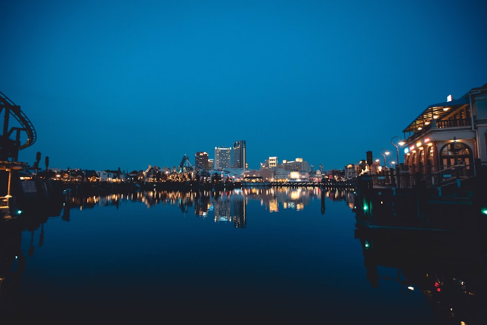 reflection of cityscape on body of water during night