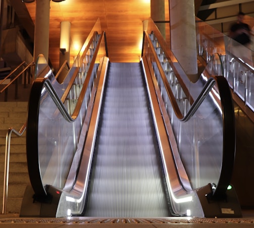 A sleek, modern escalator installed in a bustling commercial mall, showcasing smooth operation and stainless steel finish.