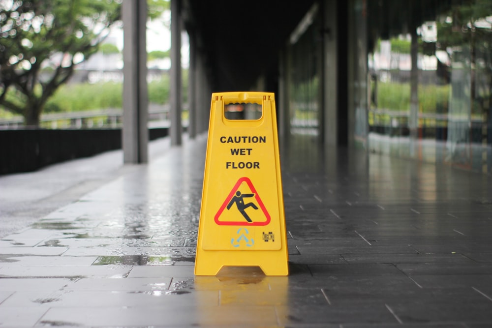 amarillo Precaución Señalización de piso mojado en pavimento mojado