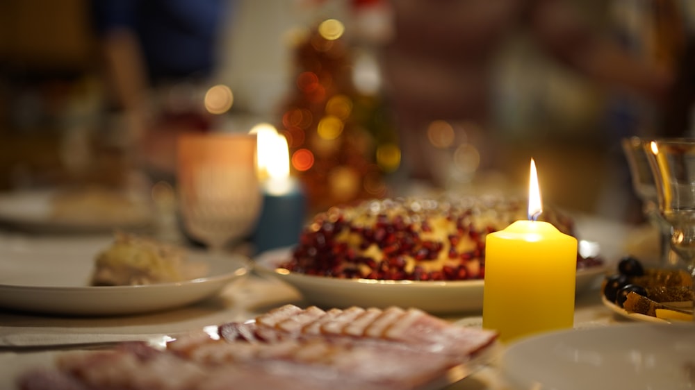 lighted pillar candles beside plates