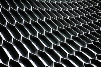 An abstract architectural structure with a repetitive honeycomb pattern of metallic hexagonal protrusions, creating an illusion of depth and complexity.