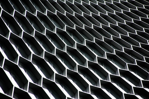 An abstract architectural structure with a repetitive honeycomb pattern of metallic hexagonal protrusions, creating an illusion of depth and complexity.