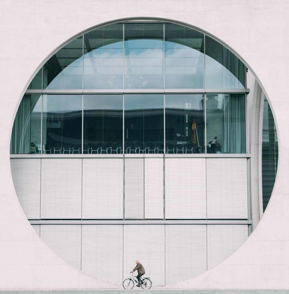 person biking by glass wall