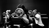 three person lifting barbels