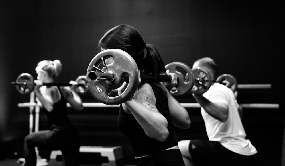 three person lifting barbels