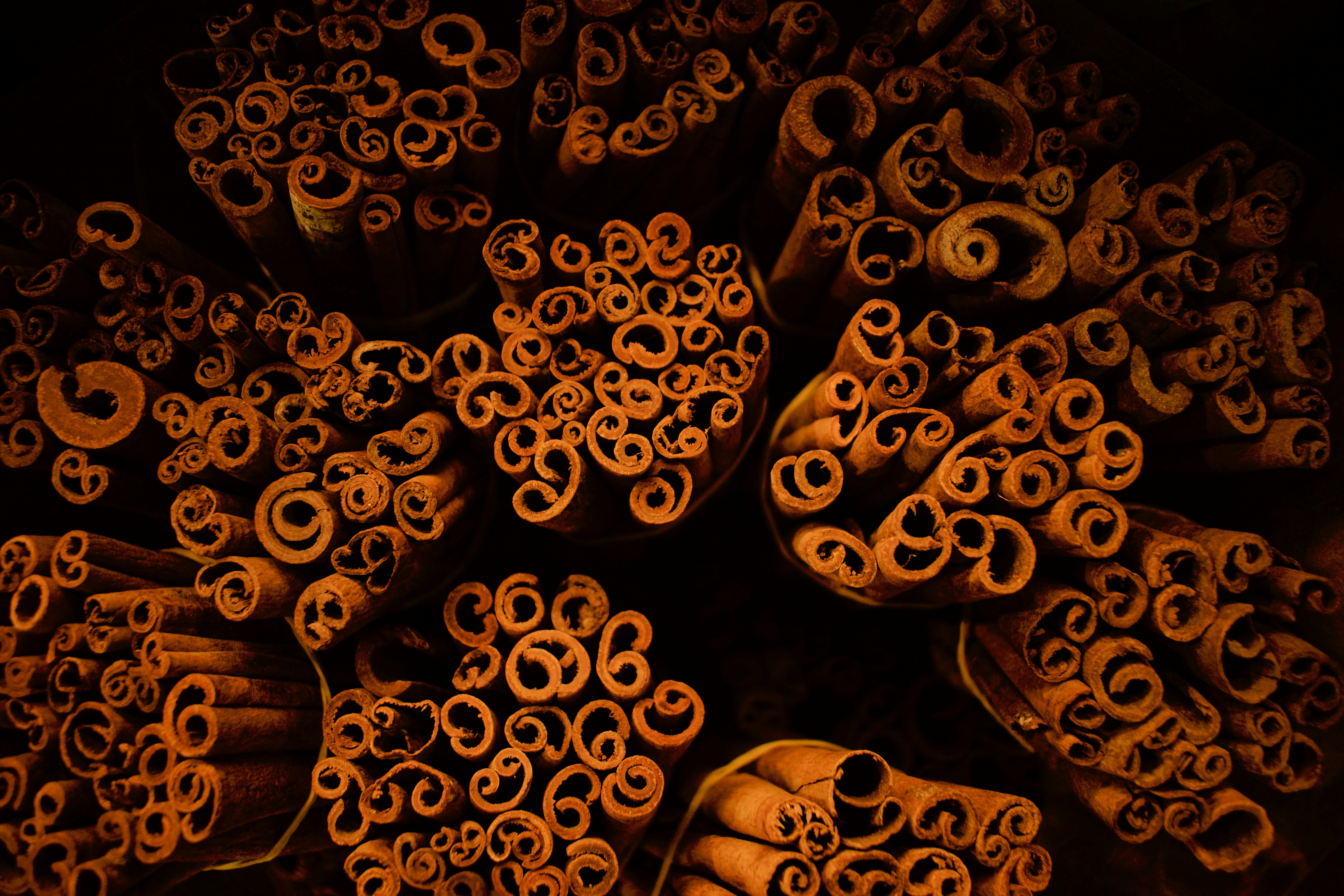 A picture taken at a spice stall in the famous spice market in Dubai showing an interesting pattern created by cinnamon sticks on display. With a limited light fallling on the subject, the background automatically became dark creating a deep effect.