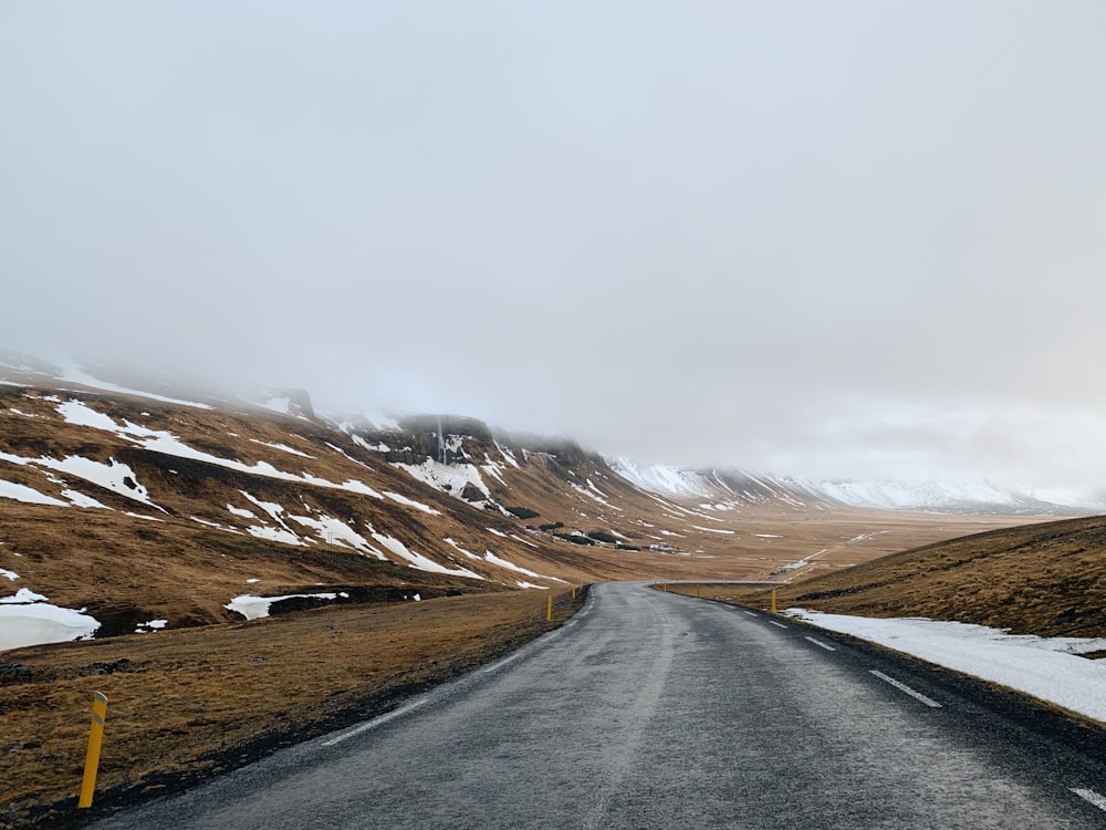 empty road between brown field at daytime