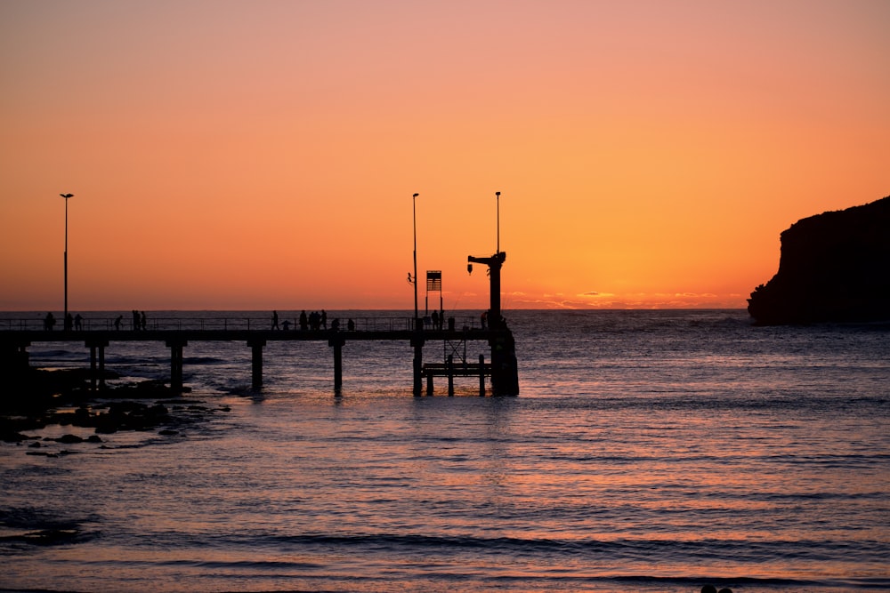 Silhouette des Docks am Meer während Golden Houer