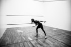 grayscale photography of person holding racket