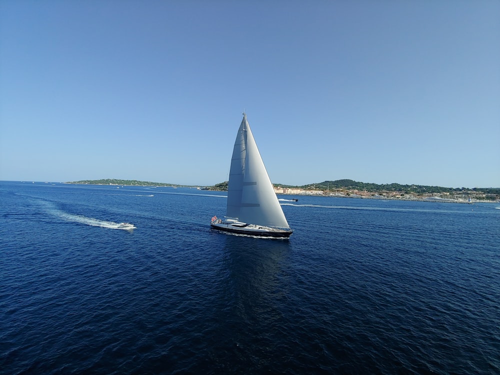 black sail boat on sea