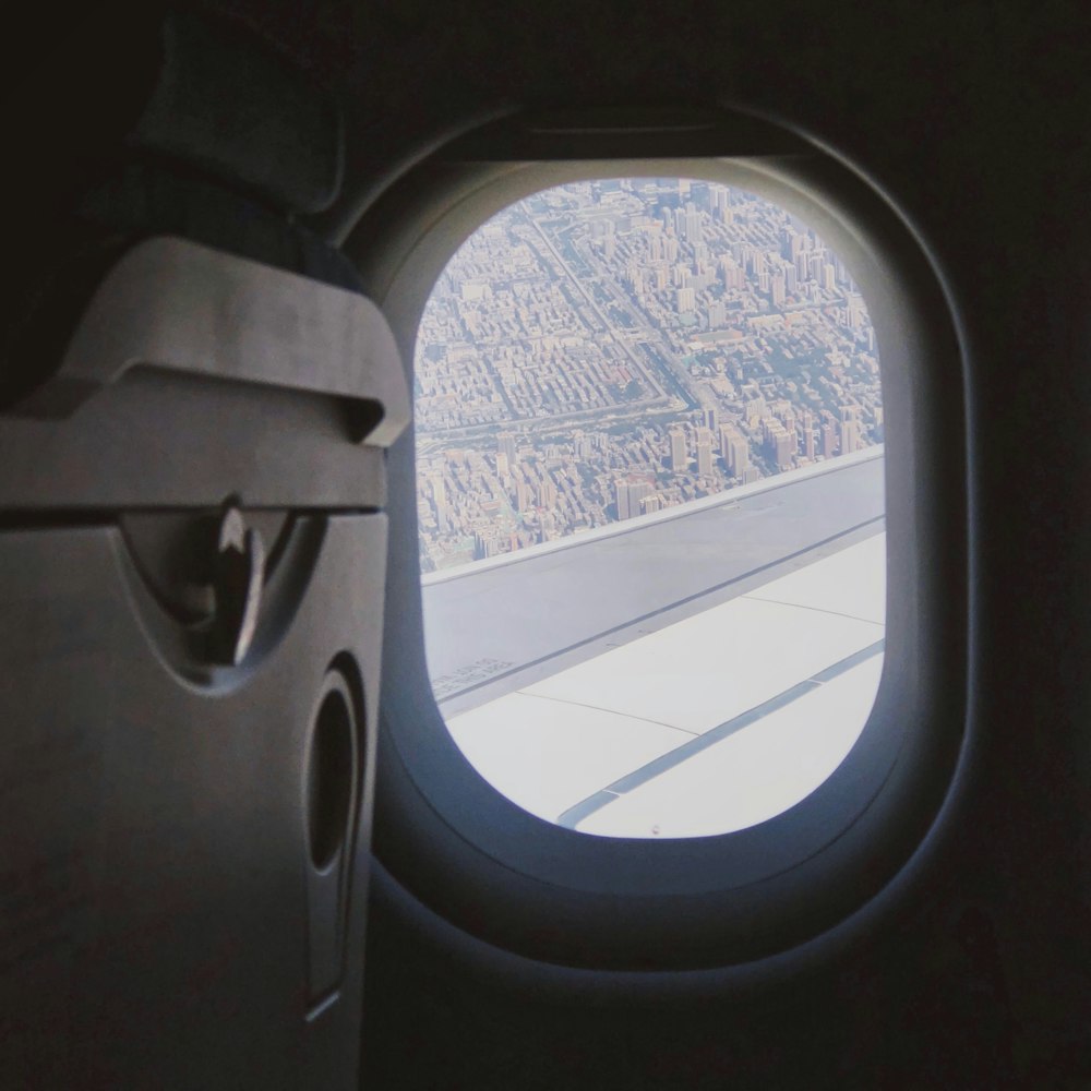 an airplane window with a view of a city