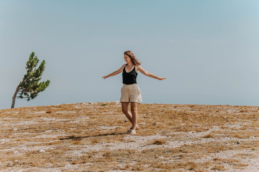 woman standing wearing black tank top during daytime