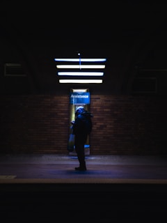 a person with a backpack is standing in the dark