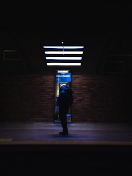 a person with a backpack is standing in the dark